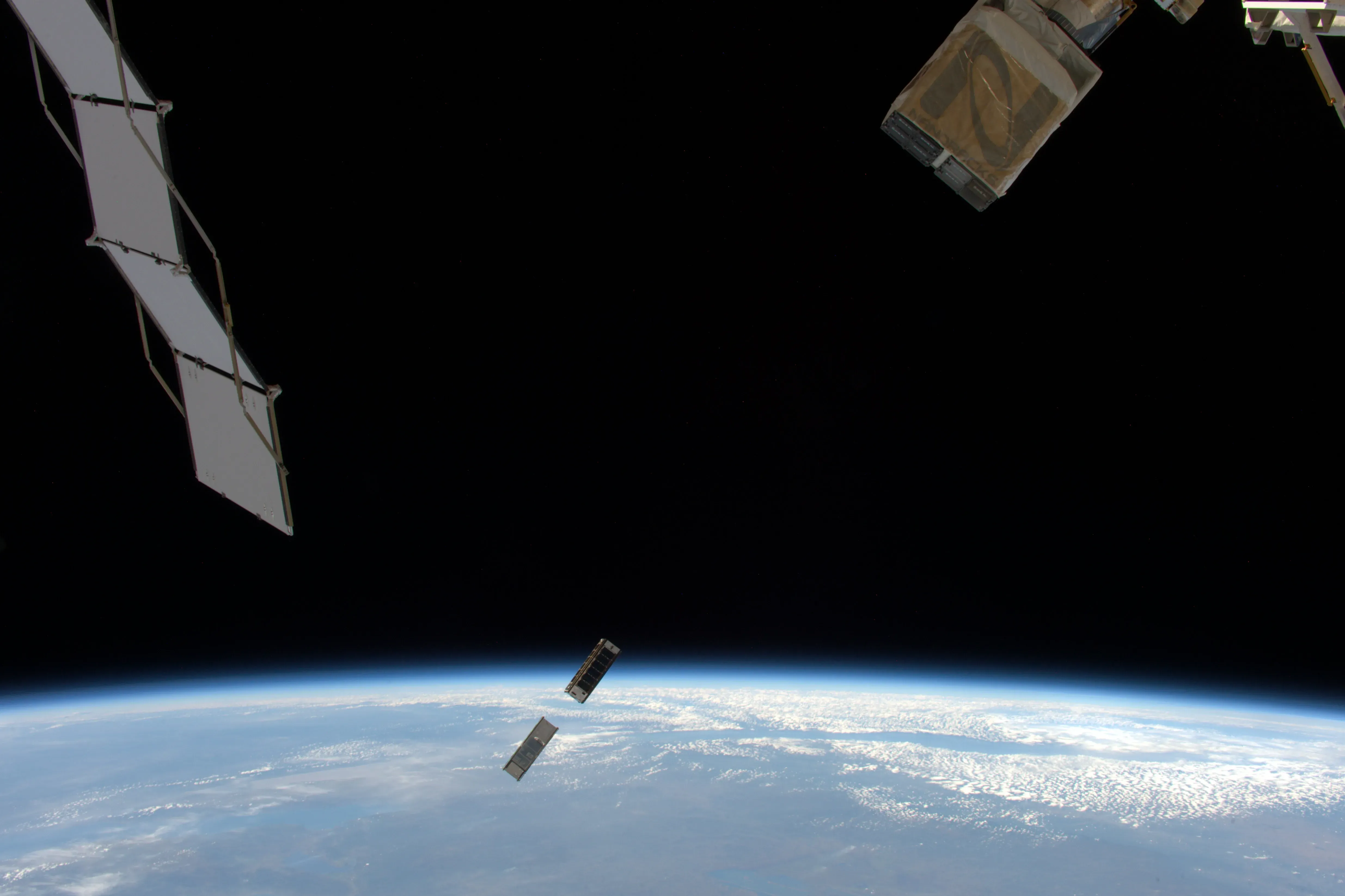 An orbital cube sattelite being deployed in space.