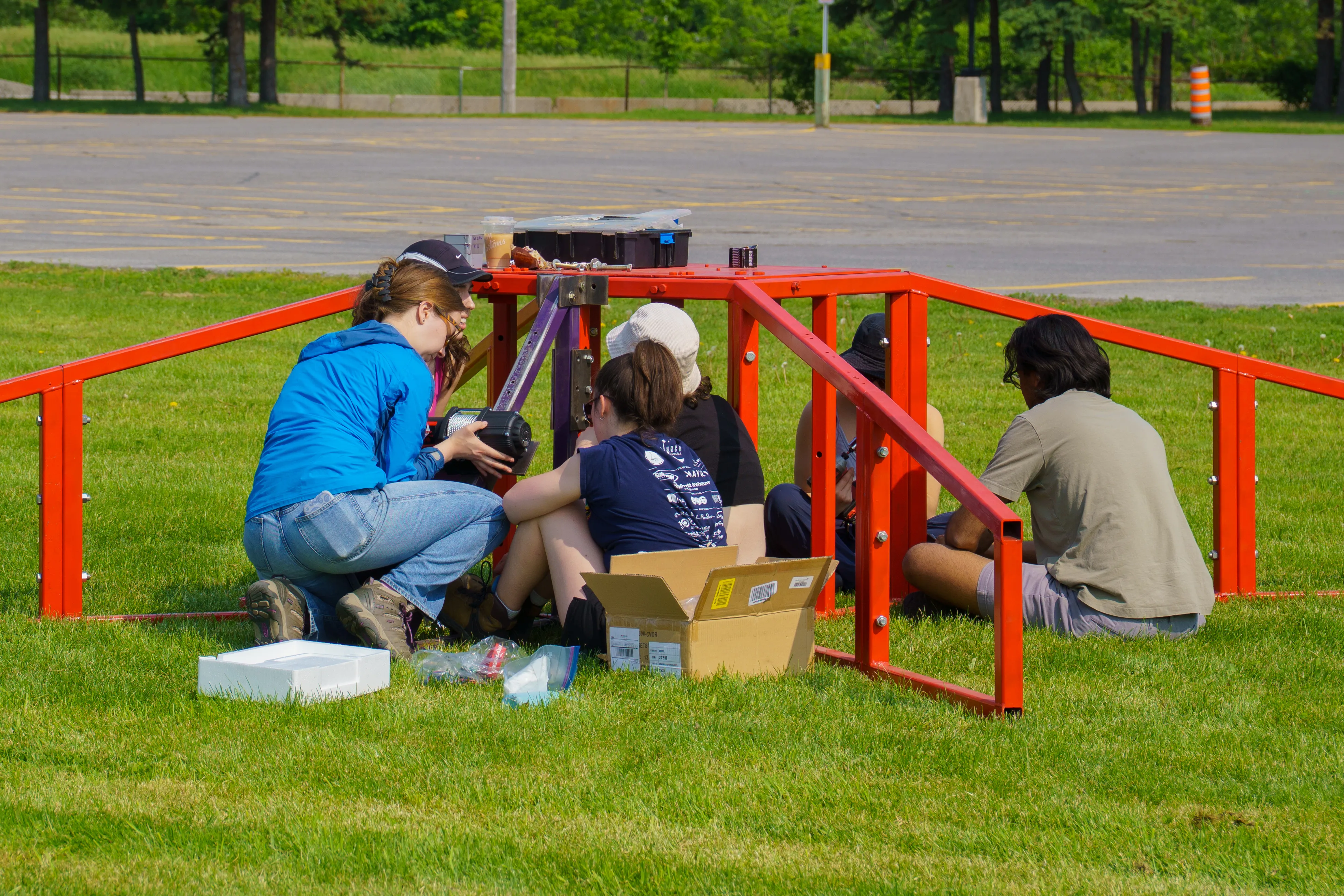 Two team members tabling at an event with a used rocket.