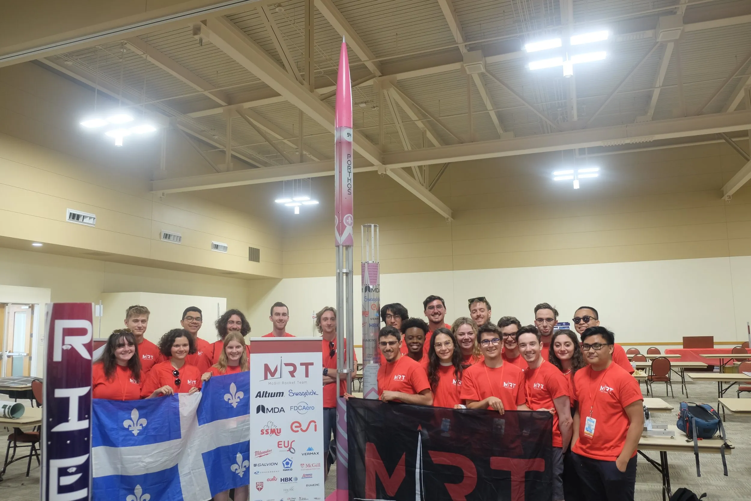 The McGill Rocket Team poses with their rocket and team banners.
